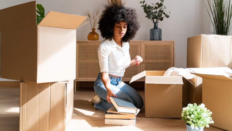 Kvinna som sitter bland flyttkartonger inför utlandsflytt